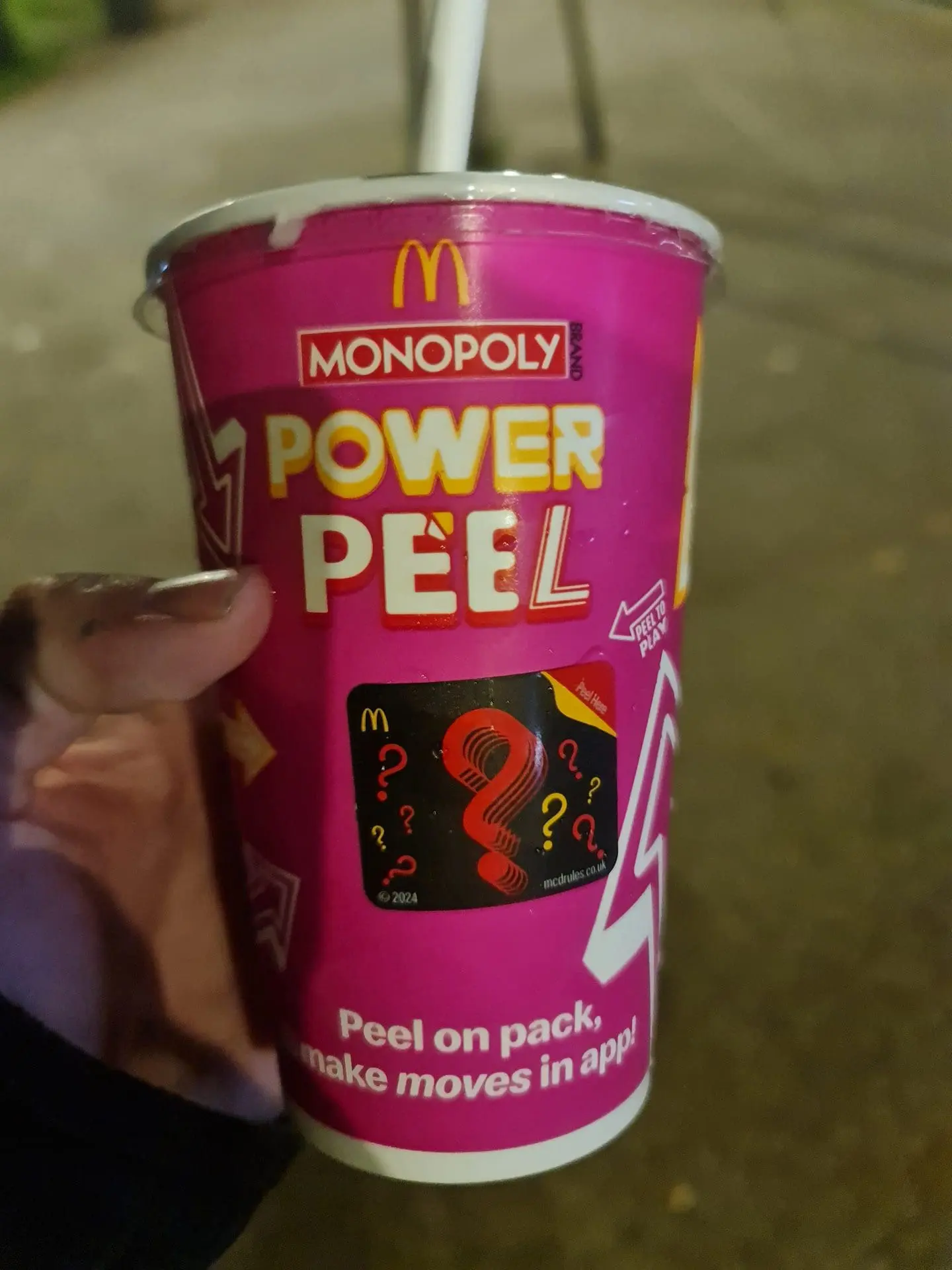 Photo of A McDonald's cup featuring the Monopoly Power Peel promotion with a pink design and a straw. | Wander Sober