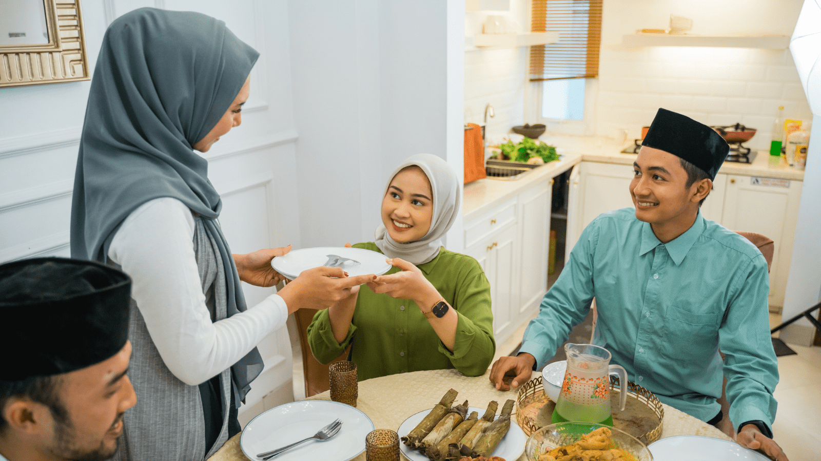 Photo of A woman serving food to two seated individuals at a dining table in a bright kitchen. | Wander Sober