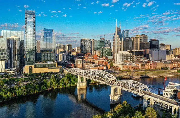 Photo of Aerial view of Nashville skyline featuring a bridge over the river and modern buildings. | Wander Sober