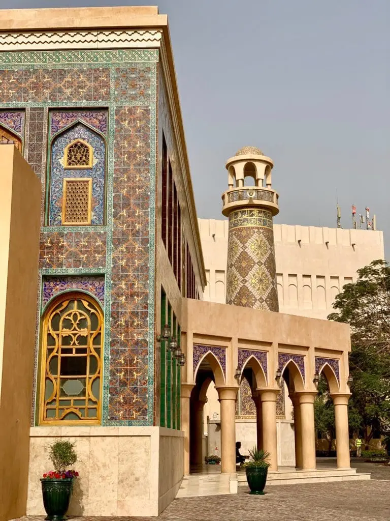 Photo of Architectural structure featuring intricate tile work and a minaret in a courtyard setting. | Wander Sober