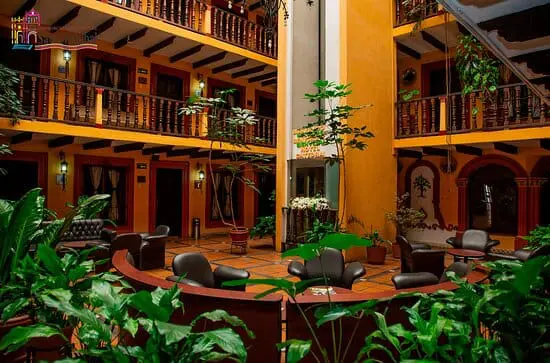 Photo of Indoor courtyard featuring seating arrangements and various indoor plants in a multi-level building. | Wander Sober