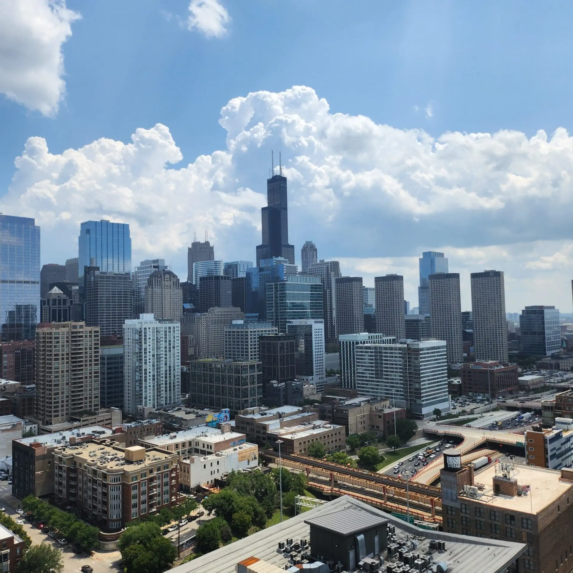 Photo of View of the Chicago skyline featuring tall buildings and the Willis Tower under a partly cloudy sky. | Wander Sober