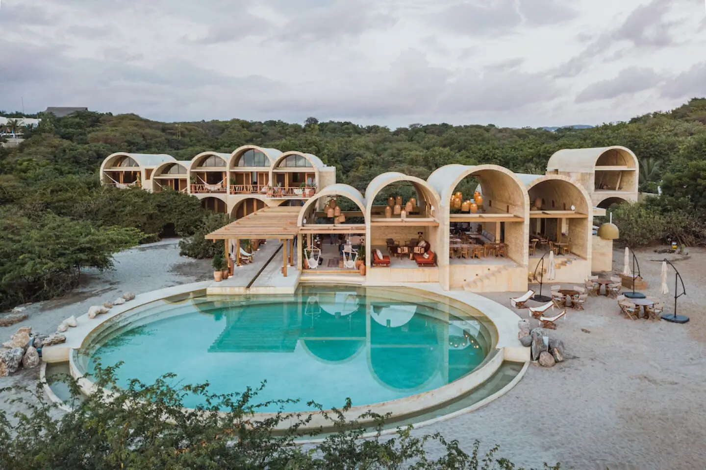 Photo of Contemporary resort featuring unique arch-shaped structures and a large swimming pool. | Wander Sober