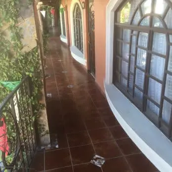 Photo of Outdoor corridor featuring tiled flooring and multiple windows along the walls. | Wander Sober
