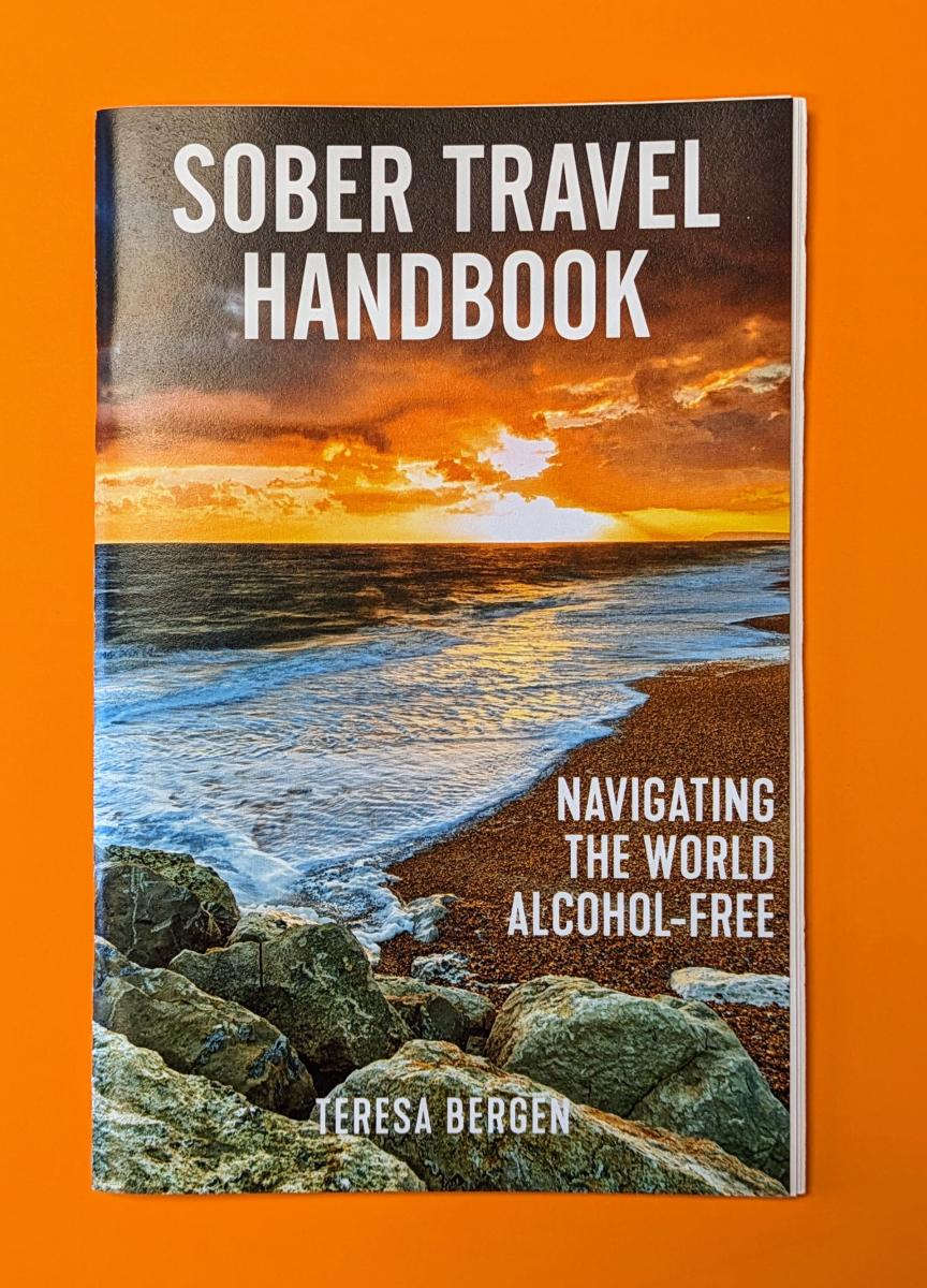 Sover Travel - Cover of Sober Travel Handbook by Teresa Bergen on an orange background. Features an ocean sunset with a rocky shoreline, and text Navigating Adventures Alcohol-Free.