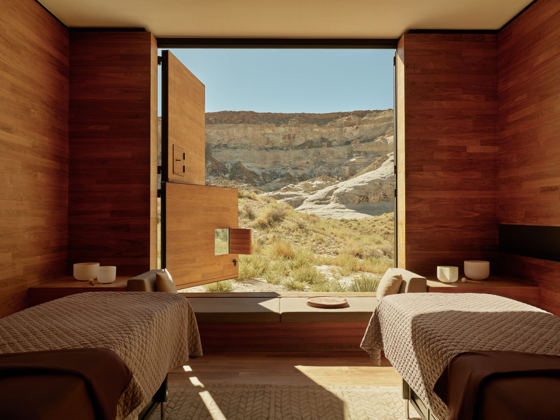 Photo of Interior of a spa treatment room with two massage tables and an open door revealing a natural landscape. | Wander Sober